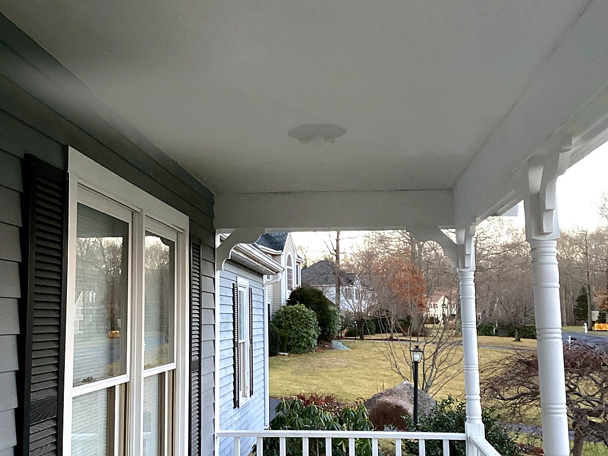 Finished smooth painted porch ceiling with light fixture installed