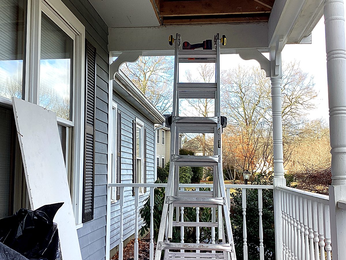 Porch ceiling torn open exposing framing and insulation during repair