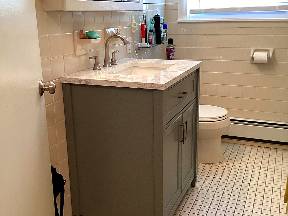 New gray bathroom vanity with marble-look top after remodel