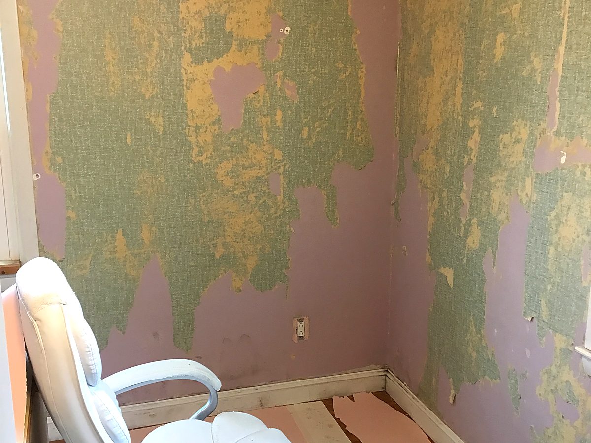 Old patterned wallpaper being stripped from bedroom walls and ceiling